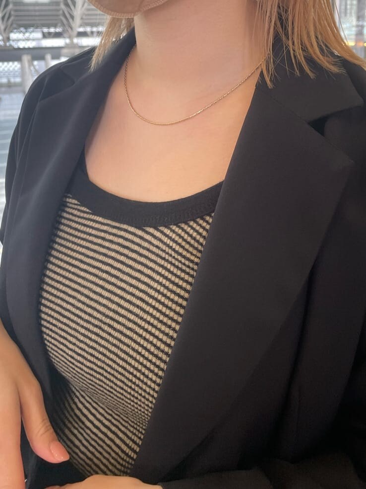 ブラック系のテーラードジャケット、ホワイト系のハンドバッグ、ブラック系のスカートを着用したレディースの春コーディネートの10枚目の写真