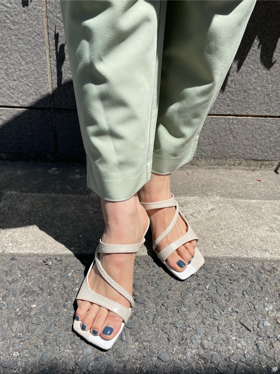 ホワイト系のワンピース、ホワイト系のサンダル、ベージュ系のかごバッグを着用したレディースの春コーディネートの4枚目の写真