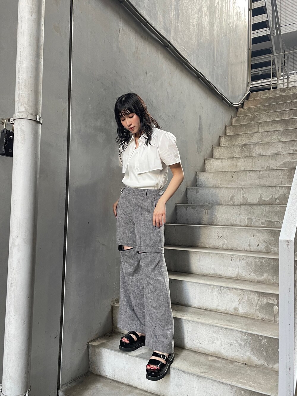 ホワイト系のシャツ/ブラウス、グレー系のスラックス、ブラック系のサンダルを着用したレディースの春コーディネートの2枚目の写真
