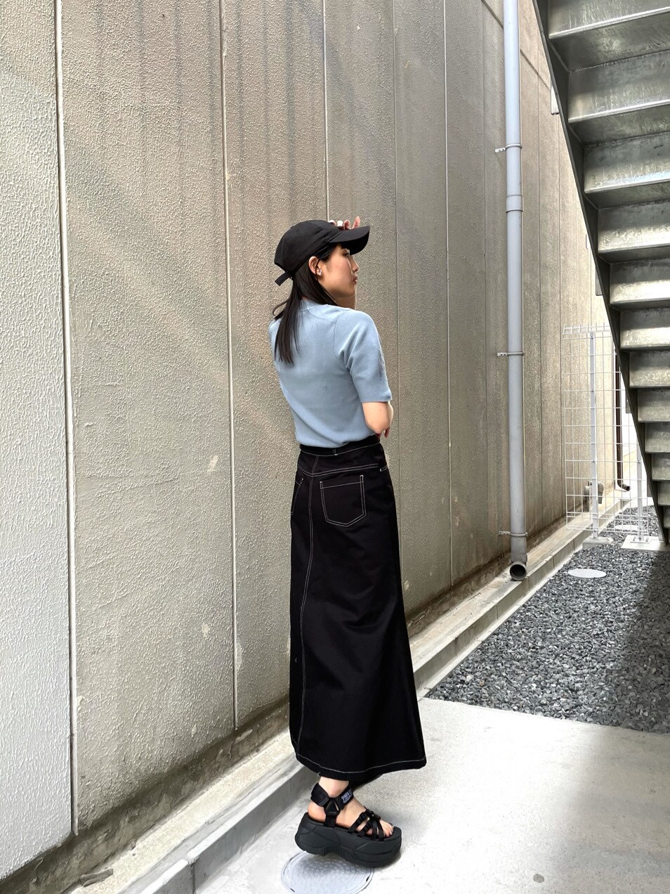 ブラック系のスカート、ブラック系のサンダル、ブルー系のニット/セーターを着用したレディースの春コーディネートの3枚目の写真