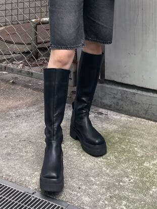 ブラック系のブーツ、ブルー系のニット/セーター、ブラック系のムートンコートを着用したレディースの秋コーディネートの10枚目の写真