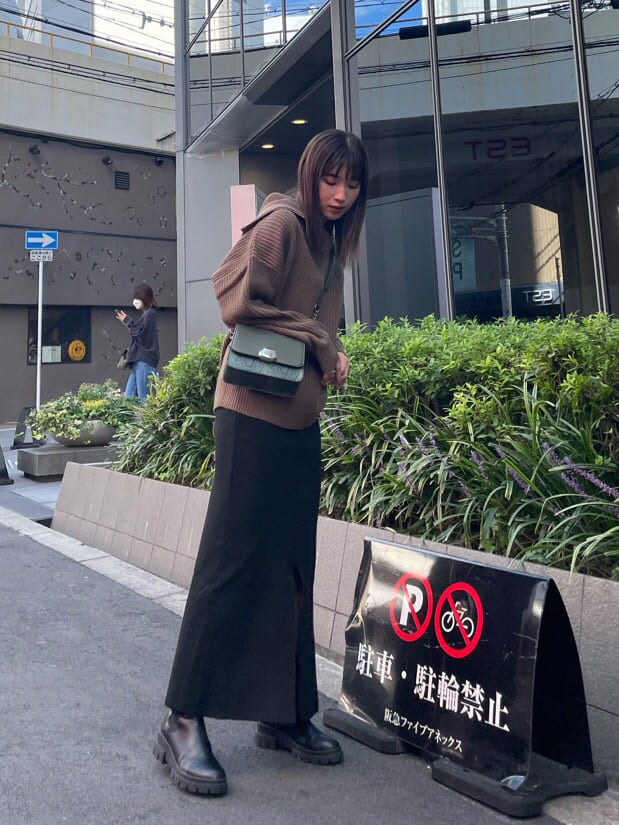 ブラック系のブーツ、ブラウン系のニット/セーター、グリーン系のショルダーバッグを着用したレディースの秋コーディネートの2枚目の写真