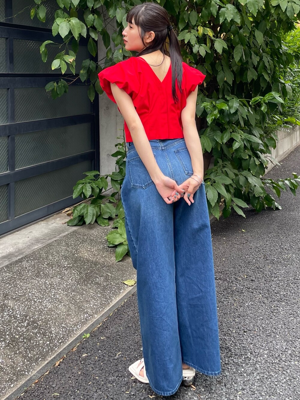 レッド系のシャツ/ブラウス、ブルー系のデニムパンツを着用したレディースの夏コーディネートの3枚目の写真