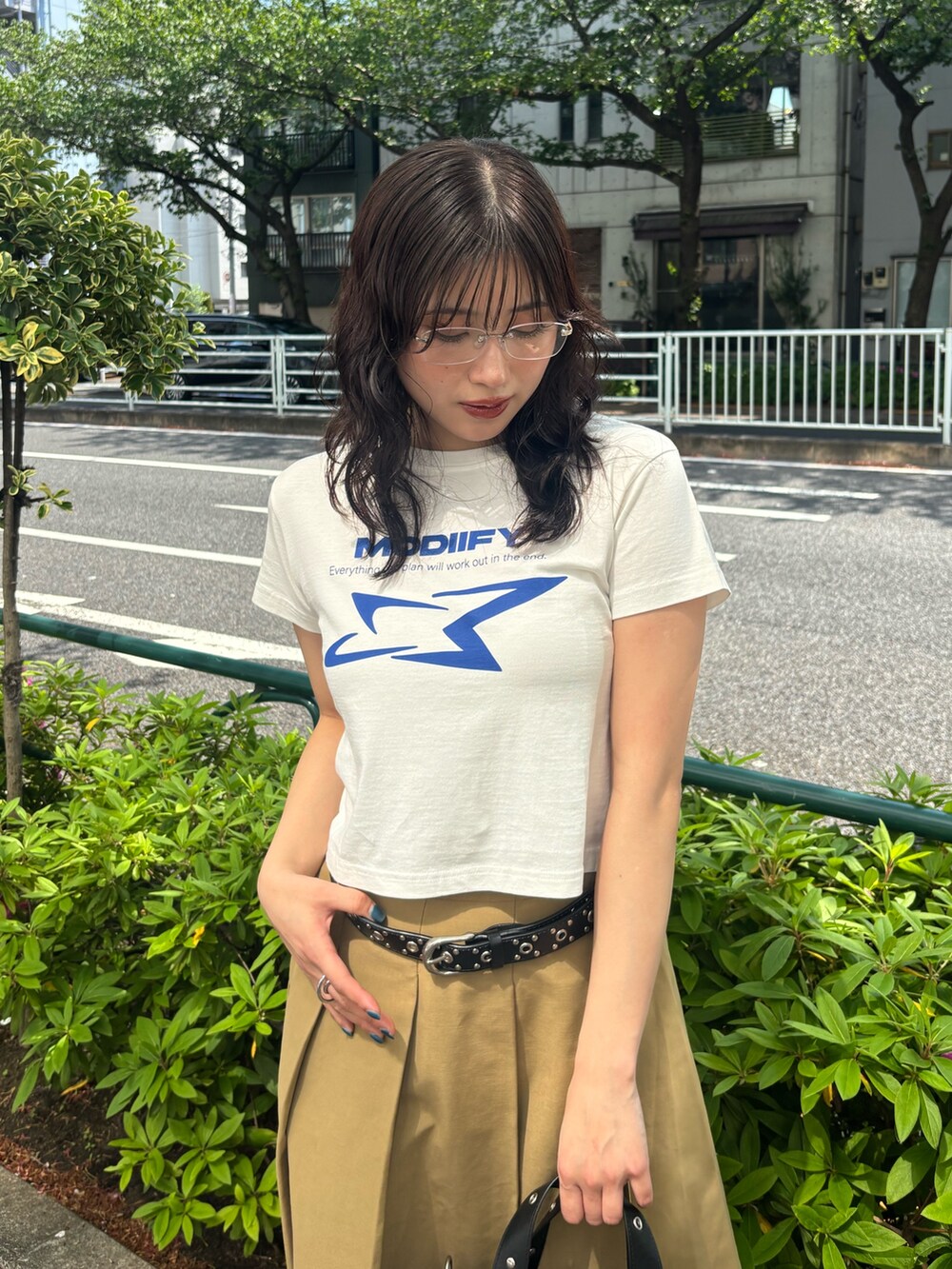 ホワイト系のTシャツ/カットソー、ブラック系のハンドバッグ、ブラック系のベルトを着用したレディースの春コーディネートの3枚目の写真