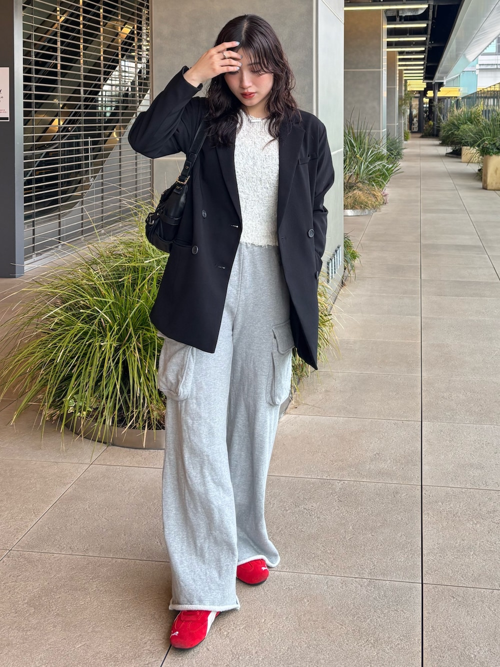 ブラック系のテーラードジャケット、ホワイト系のニット/セーターを着用したレディースの春コーディネートの2枚目の写真