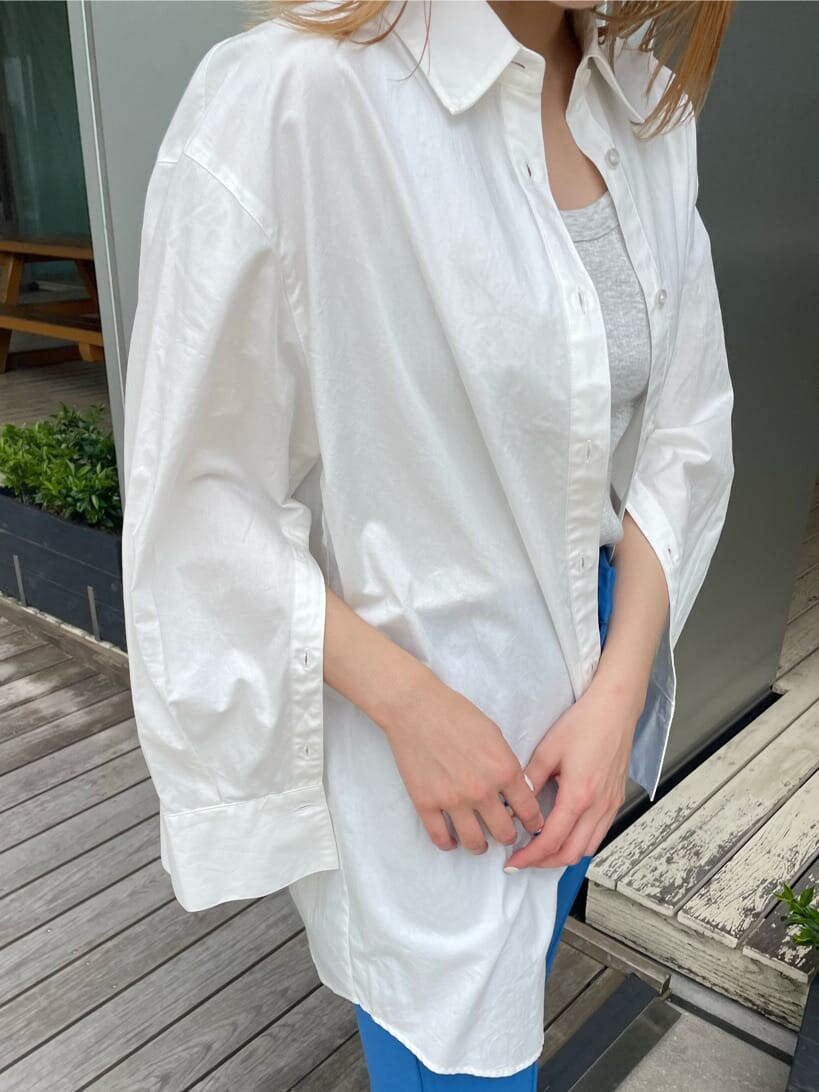 ベージュ系のスニーカー、ホワイト系のシャツ/ブラウス、ブルー系のスラックスを着用したレディースの春コーディネートの6枚目の写真