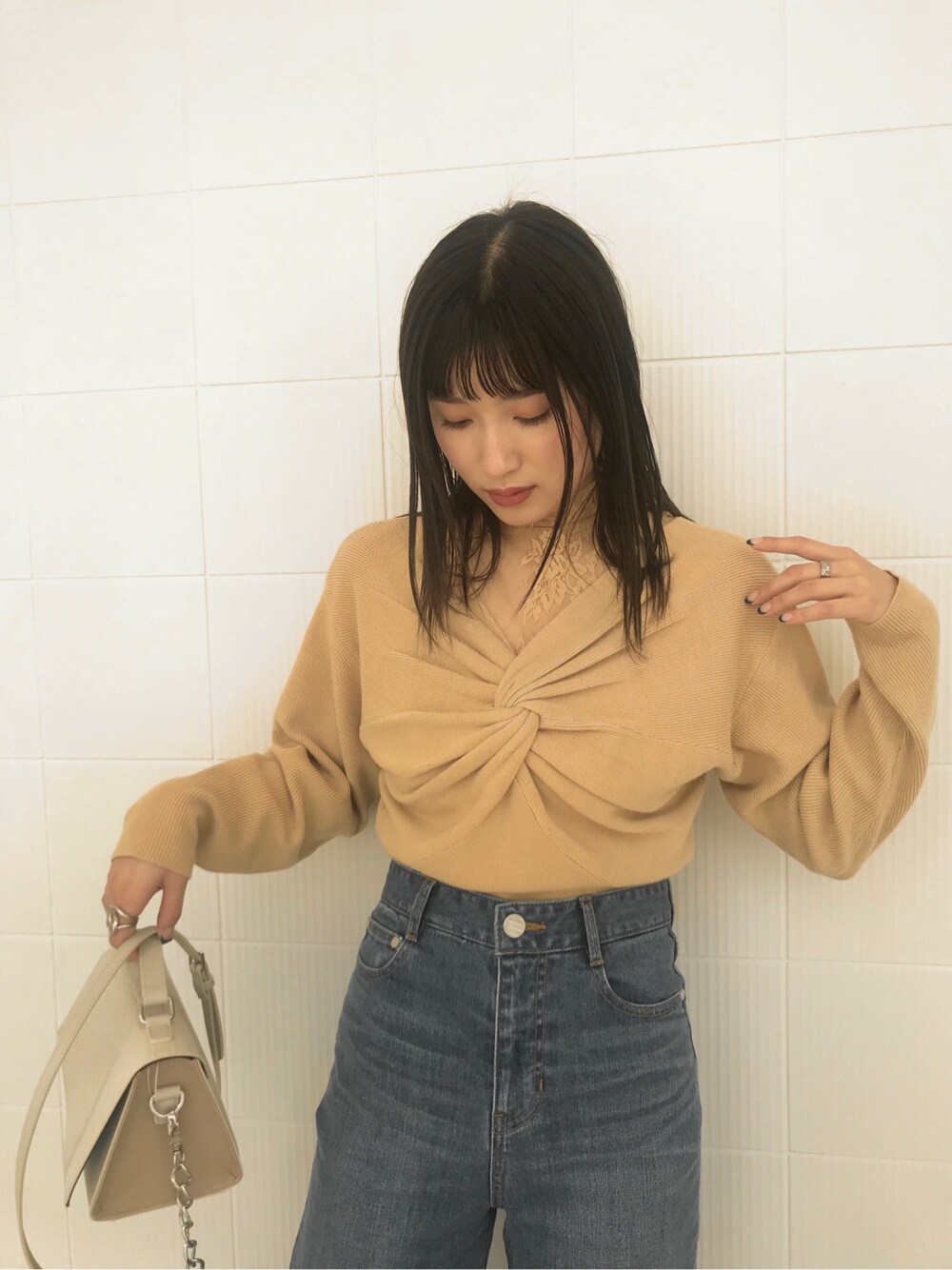 ホワイト系のローファー、ブルー系のデニムパンツ、ホワイト系のハンドバッグを着用したレディースの冬コーディネートの3枚目の写真