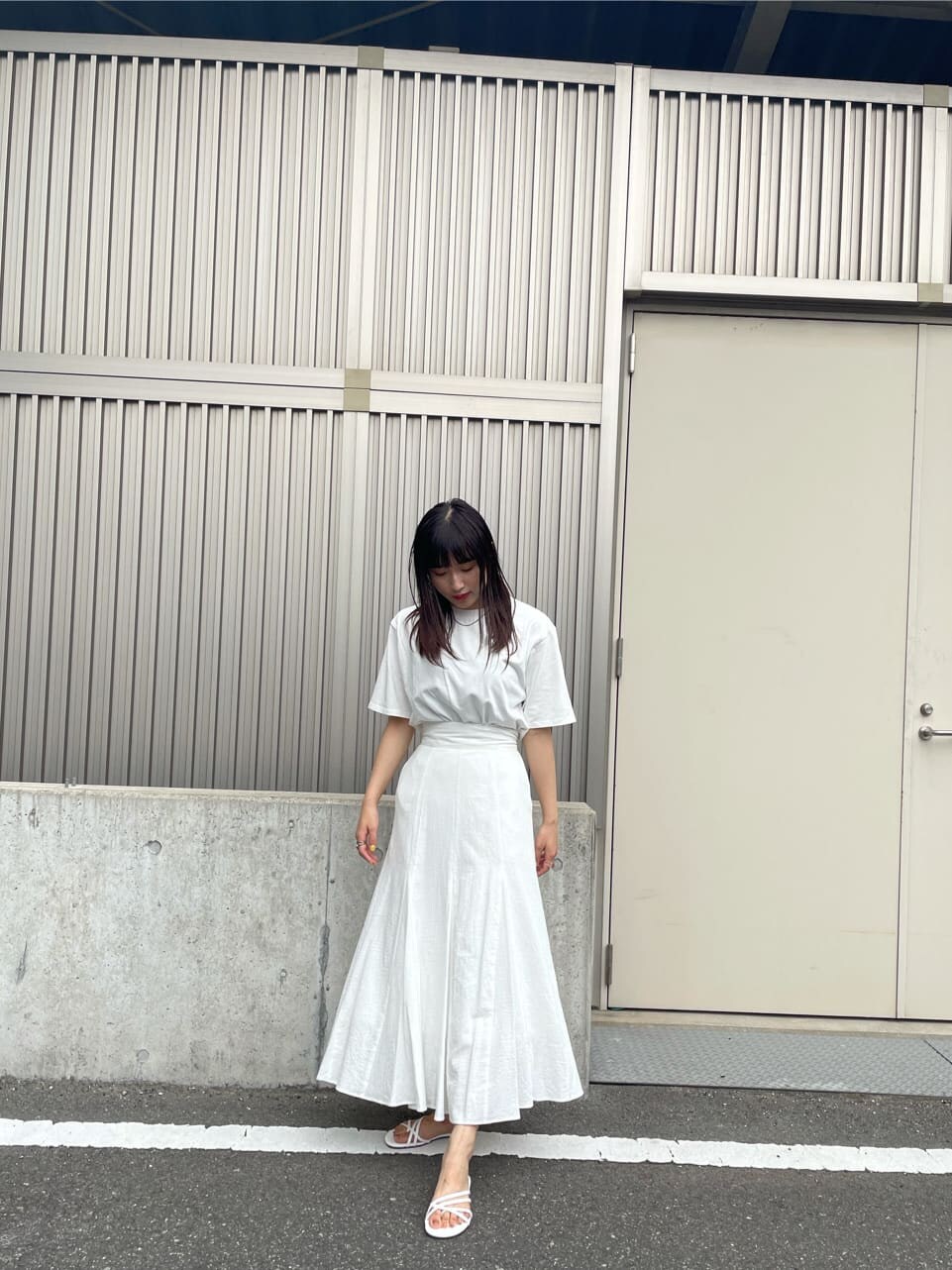 ホワイト系のスカート、ホワイト系のサンダル、ホワイト系のTシャツ/カットソーを着用したレディースの夏コーディネートの4枚目の写真