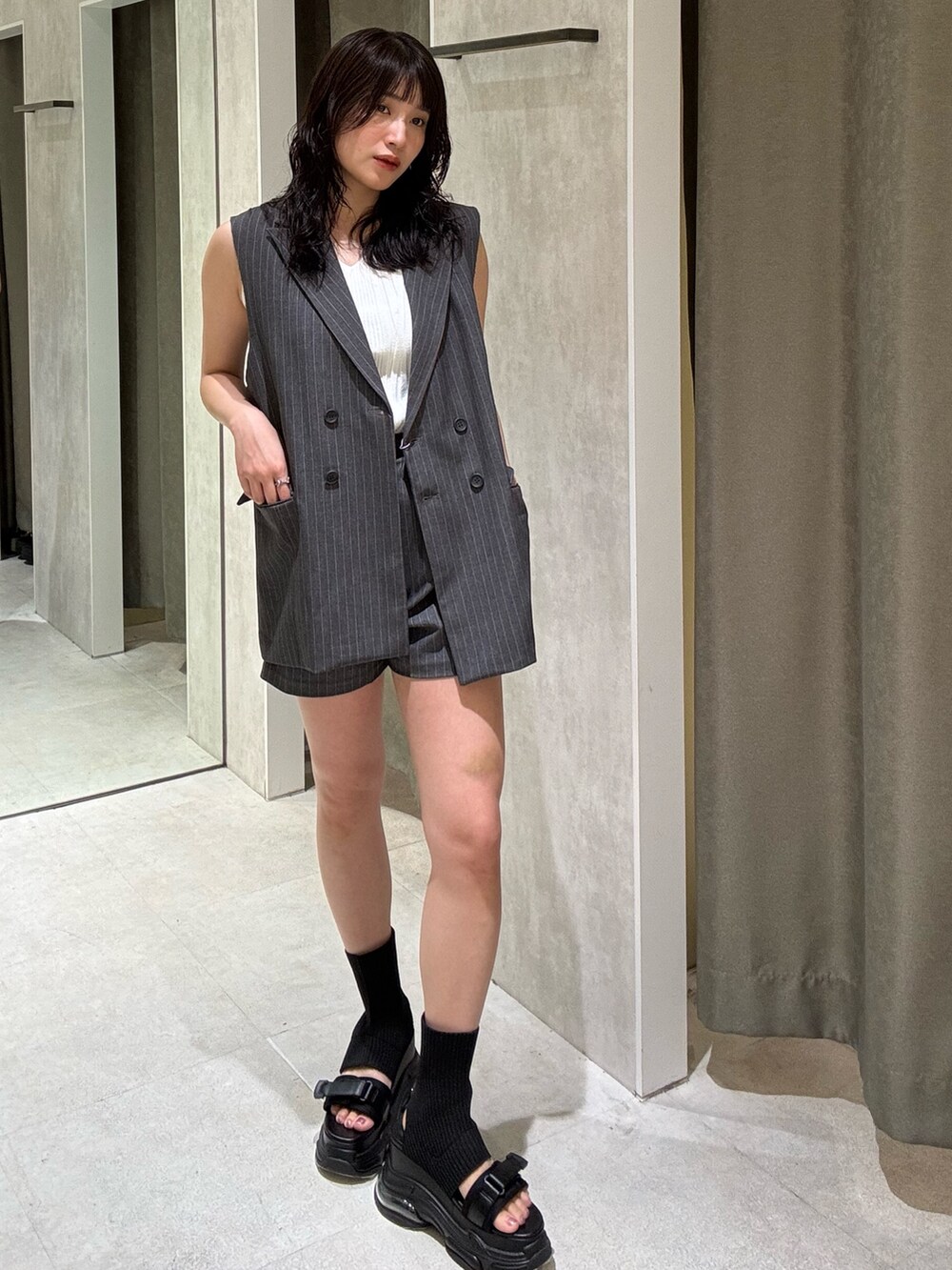グレー系のベスト、グレー系のその他パンツ、ブラック系のサンダルを着用したレディースの夏コーディネートの2枚目の写真