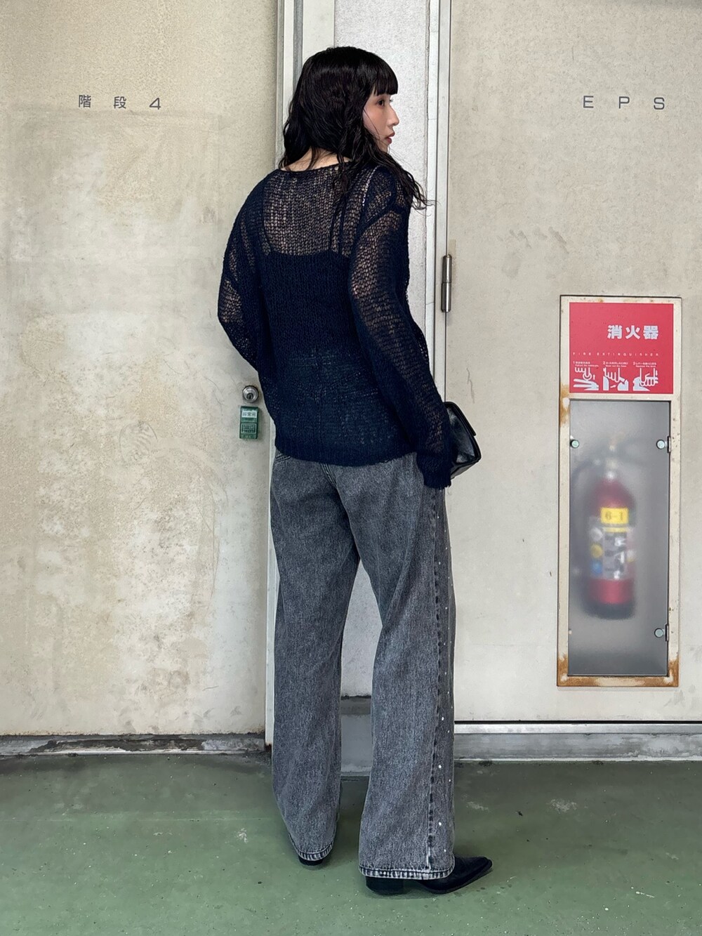 ブラック系のデニムパンツを着用したレディースの秋コーディネートの3枚目の写真