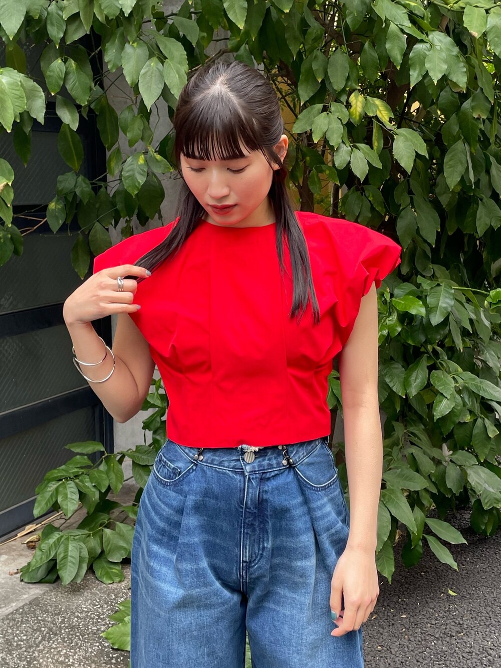 レッド系のシャツ/ブラウス、ブルー系のデニムパンツを着用したレディースの夏コーディネートの4枚目の写真