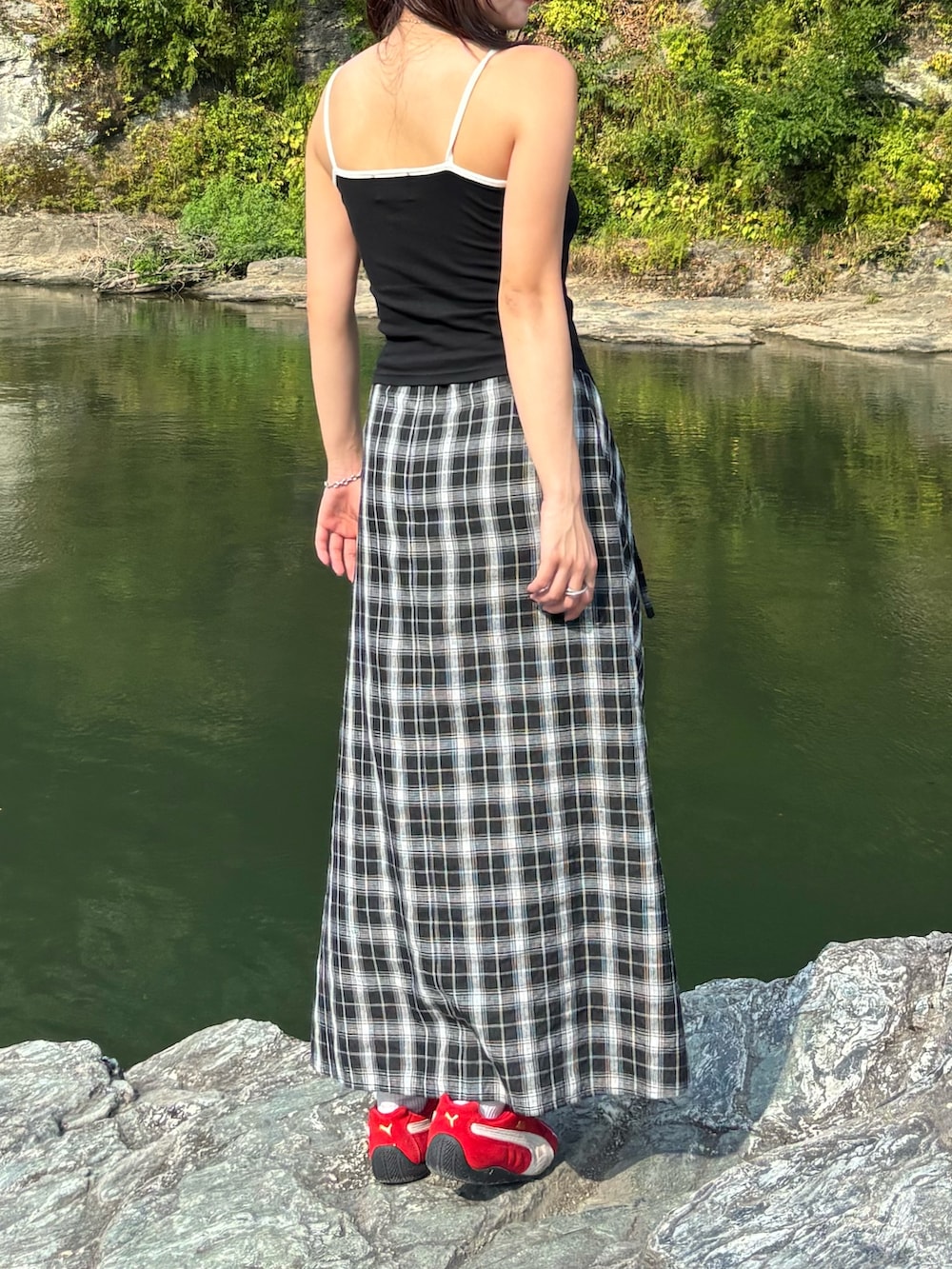 ブラック系のスカート、ブラウン系のハンドバッグを着用したレディースの夏コーディネートの2枚目の写真