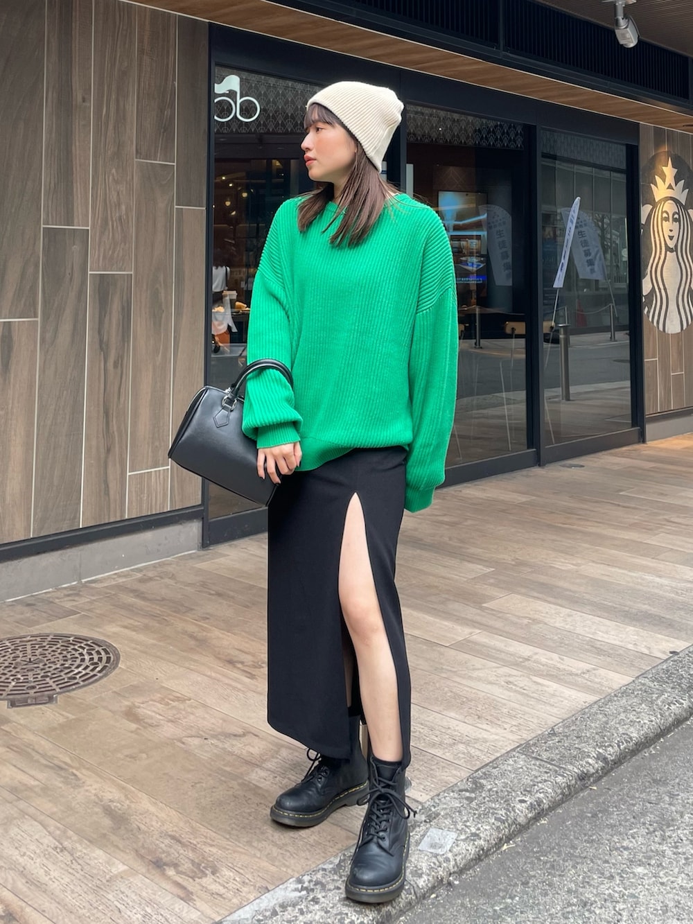 グリーン系のニット/セーター、ブラック系のスカートを着用したレディースの冬コーディネートの3枚目の写真