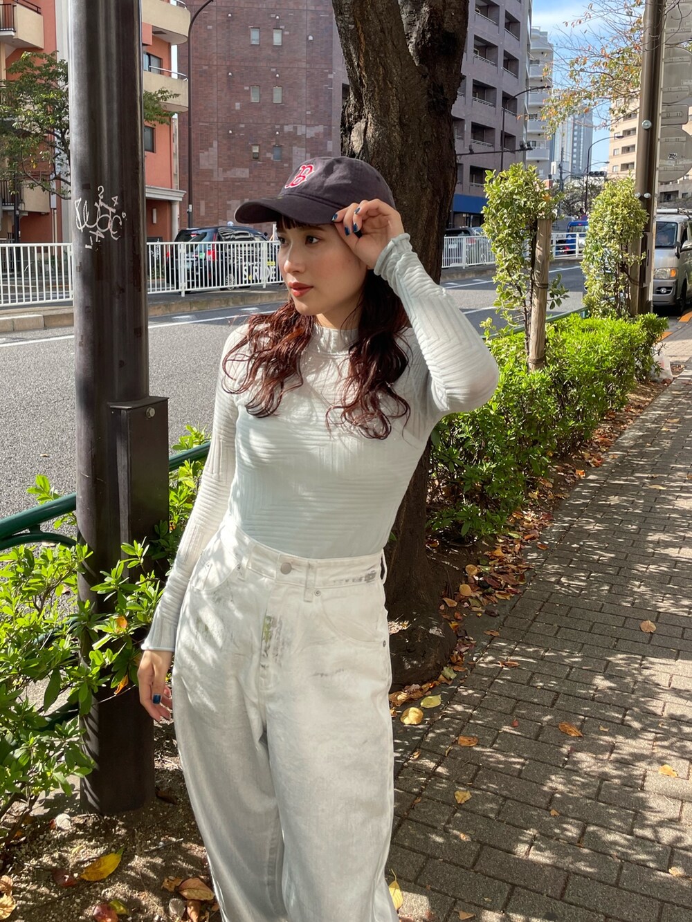 ブルー系のニット/セーター、ホワイト系のデニムパンツを着用したレディースの秋コーディネートの3枚目の写真