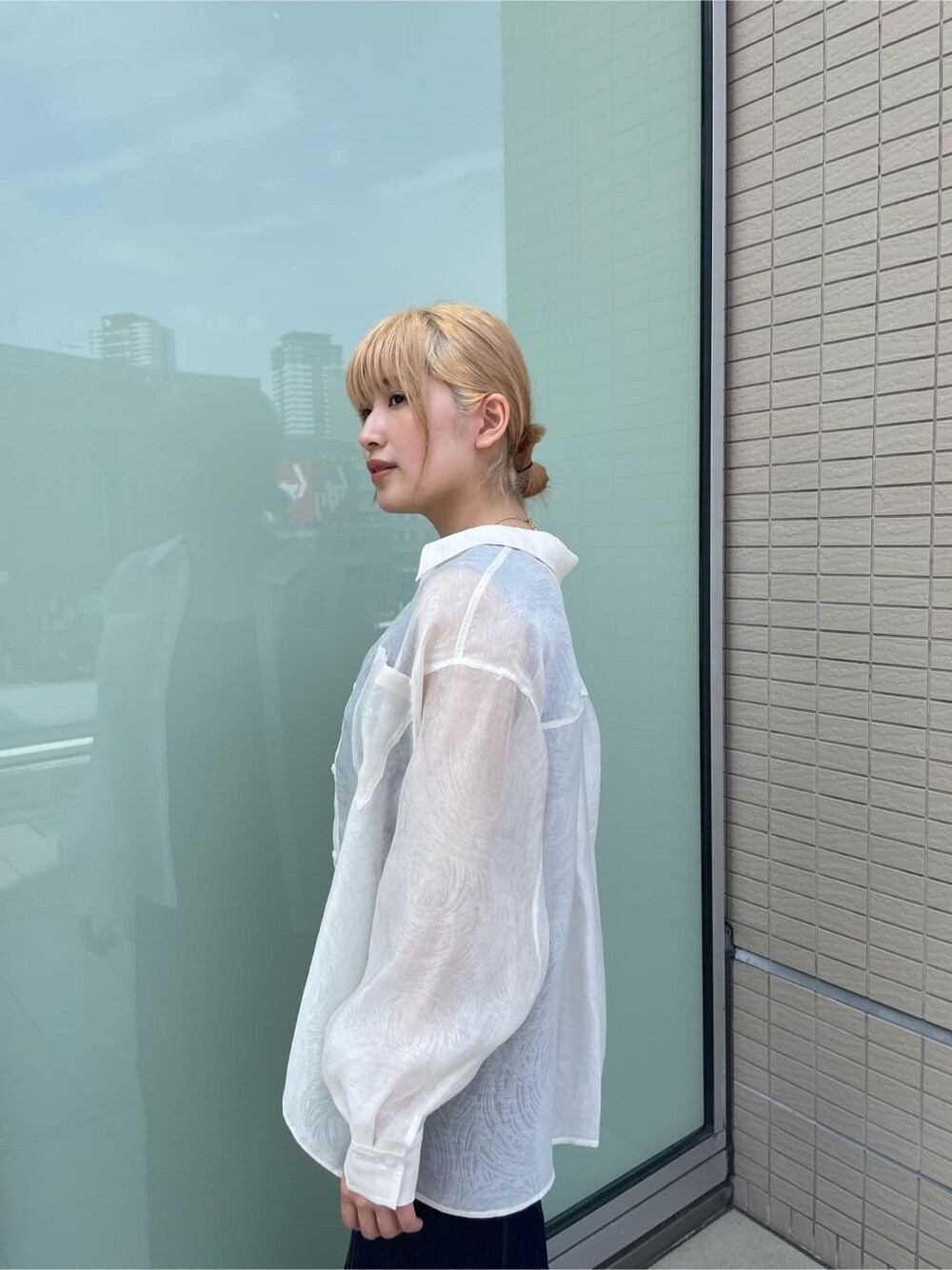 ブルー系のタンクトップ、ブルー系のデニムスカート、ホワイト系のサンダルを着用したレディースの春コーディネートの6枚目の写真