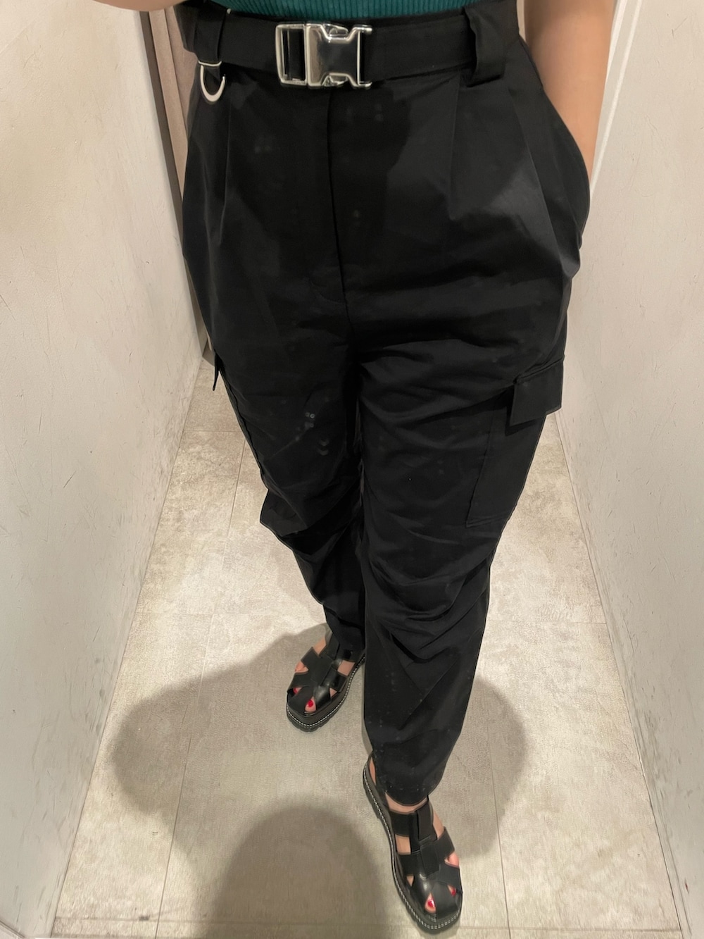 グリーン系のニット/セーター、ブラック系のカーゴパンツ、ブラック系のサンダルを着用したレディースの春コーディネートの5枚目の写真