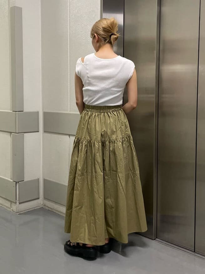 ブラック系のハンドバッグ、ブラック系のサンダル、ホワイト系のタンクトップを着用したレディースの夏コーディネートの5枚目の写真