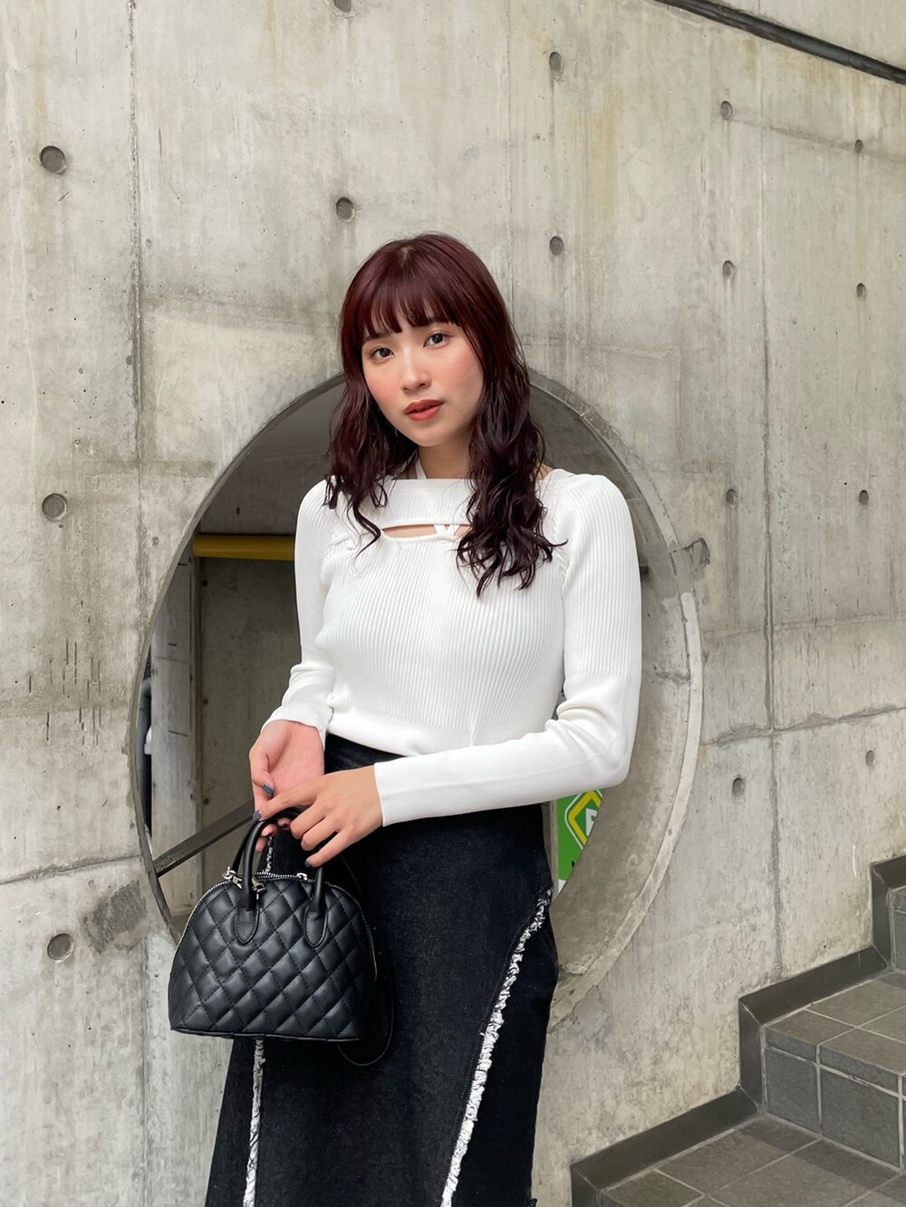 ホワイト系のニット/セーター、ブラック系のデニムスカートを着用したレディースの冬コーディネートの3枚目の写真