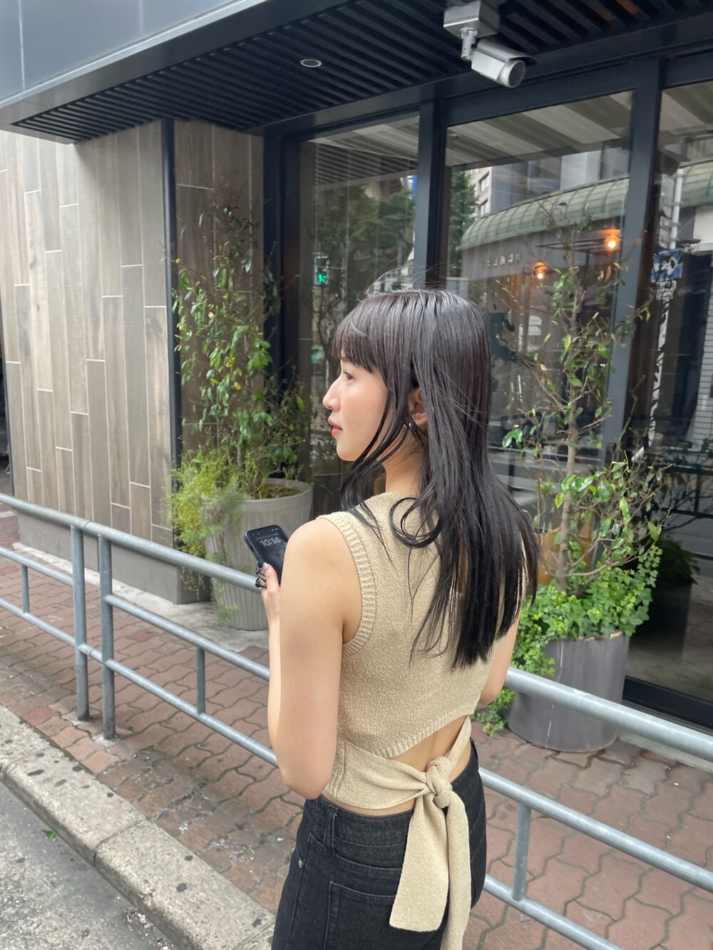 ホワイト系のタンクトップ、ブラック系のデニムパンツ、ブラック系のサンダルを着用したレディースの春コーディネートの3枚目の写真