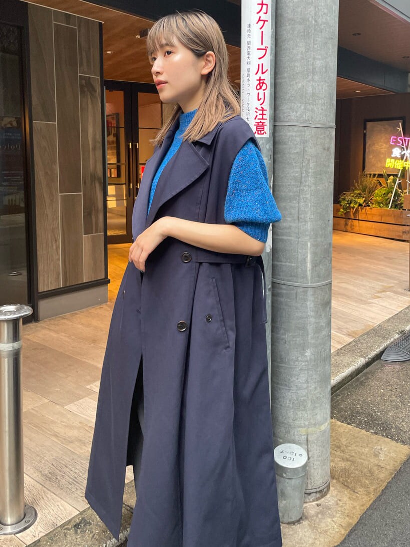 ブルー系のニット/セーター、ブルー系のトレンチコート、グレー系のスラックスを着用したレディースの秋コーディネートの5枚目の写真