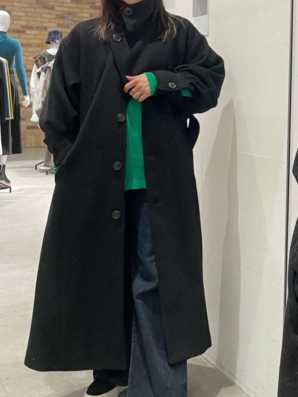 ブラック系のダウンジャケット/コート、グリーン系のニット/セーターを着用したレディースの冬コーディネートの7枚目の写真