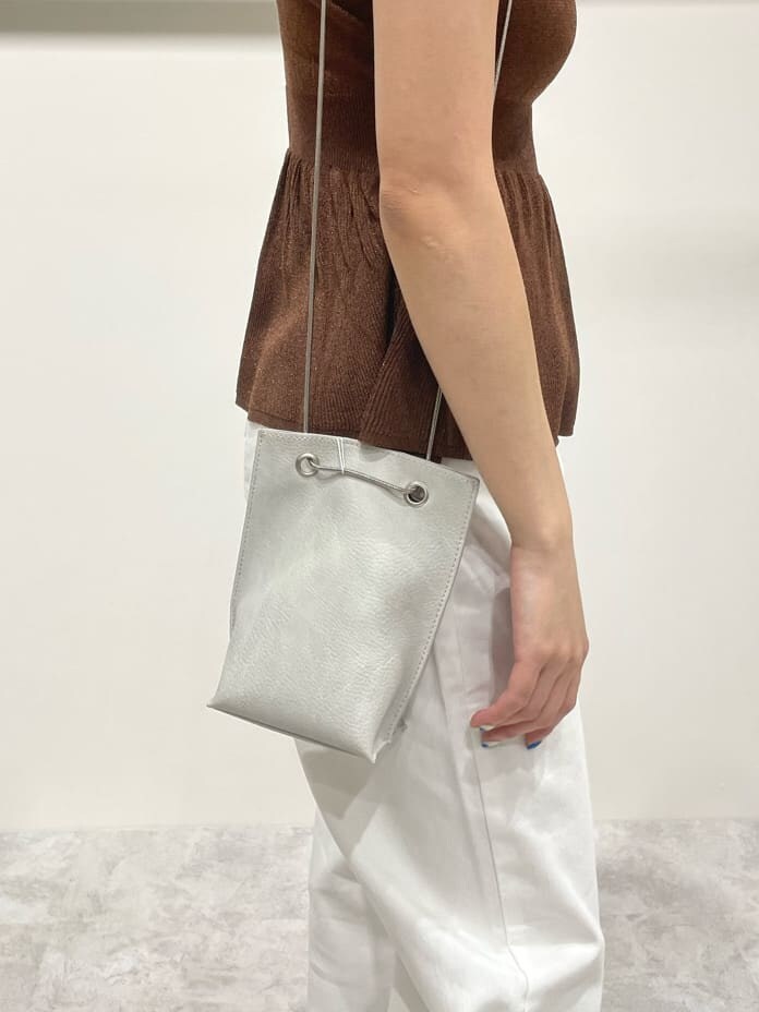 ホワイト系のデニムパンツ、ブラウン系のワンピース、ホワイト系のショルダーバッグを着用したレディースの春コーディネートの8枚目の写真