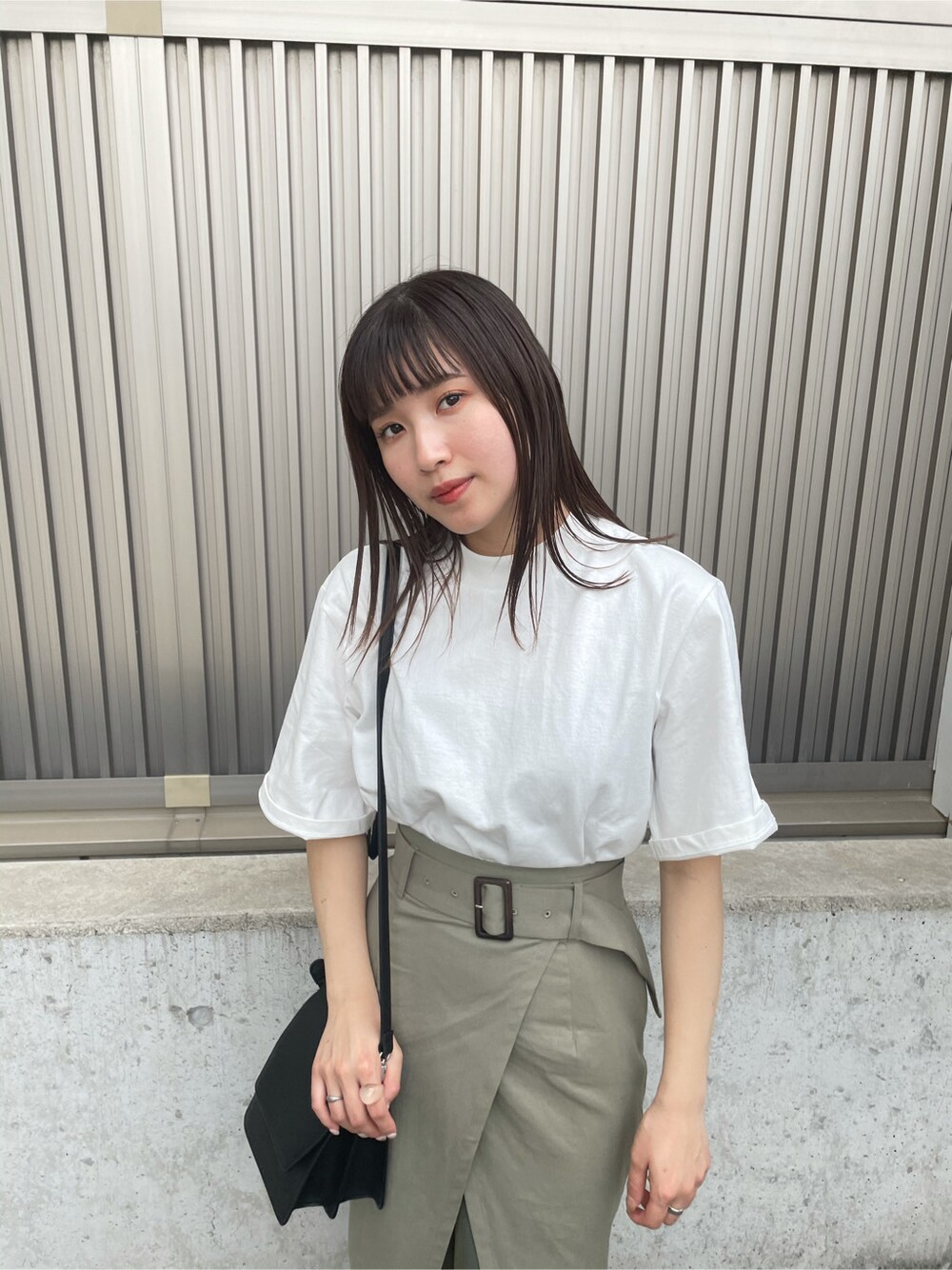 ベージュ系のスカート、ブラック系のサンダル、ホワイト系のTシャツ/カットソーを着用したレディースの春コーディネートの3枚目の写真