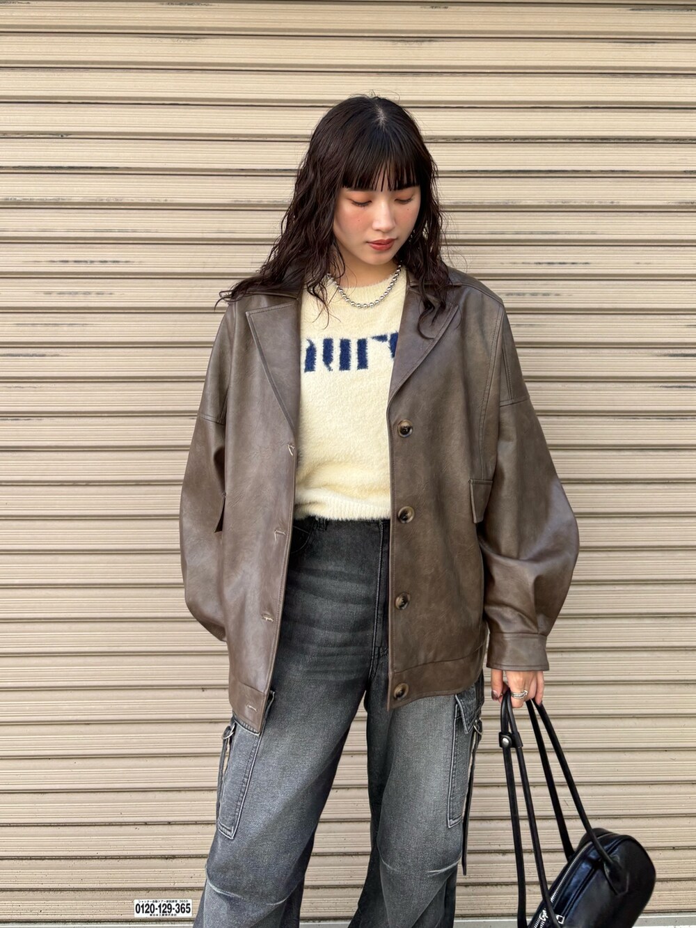 ブラウン系のブルゾン、ブラック系のデニムパンツ、ホワイト系のニット/セーターを着用したレディースの秋コーディネートの3枚目の写真