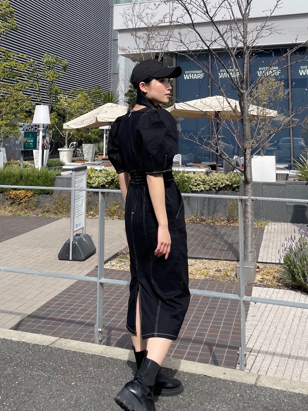 ブラック系のワンピースを着用したレディースの春コーディネートの2枚目の写真