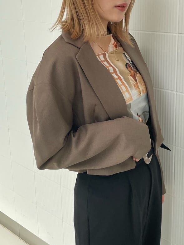 ブラック系のブーツ、ブラック系のスラックス、ブラウン系のテーラードジャケットを着用したレディースの春コーディネートの5枚目の写真