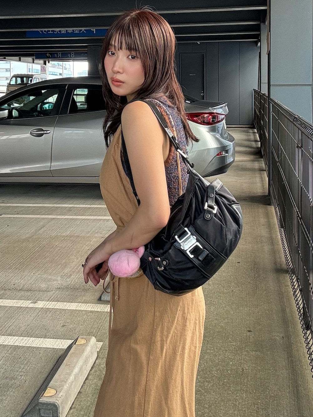 ブラウン系のニット/セーターを着用したレディースの夏コーディネートの2枚目の写真