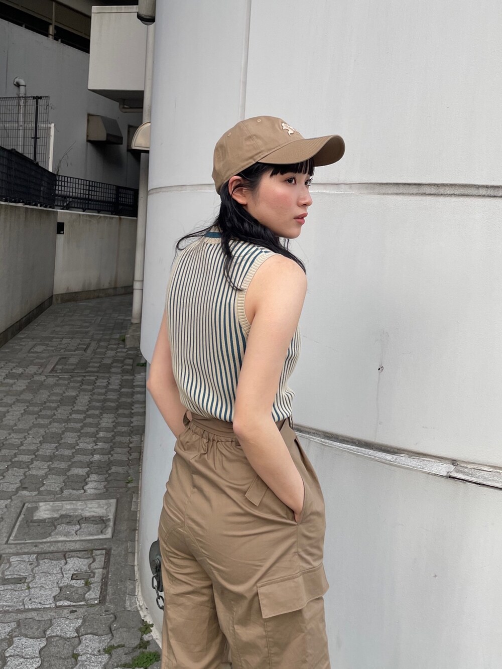 グリーン系のカーゴパンツ、ベージュ系のニット/セーター、ベージュ系のキャップを着用したレディースの春コーディネートの4枚目の写真