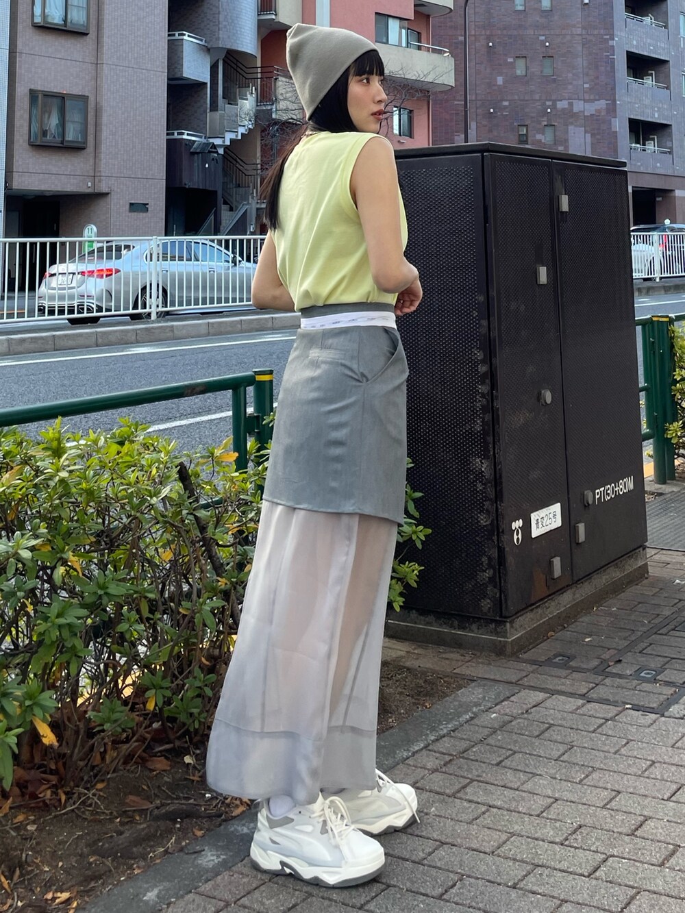 グレー系のスニーカー、イエロー系のタンクトップを着用したレディースの冬コーディネートの4枚目の写真