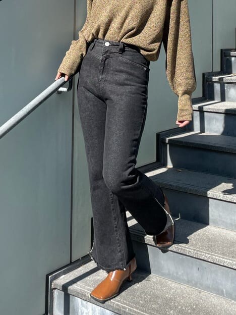 ブラウン系のブーツ、ブラック系のデニムパンツ、イエロー系のニット/セーターを着用したレディースの秋コーディネートの2枚目の写真