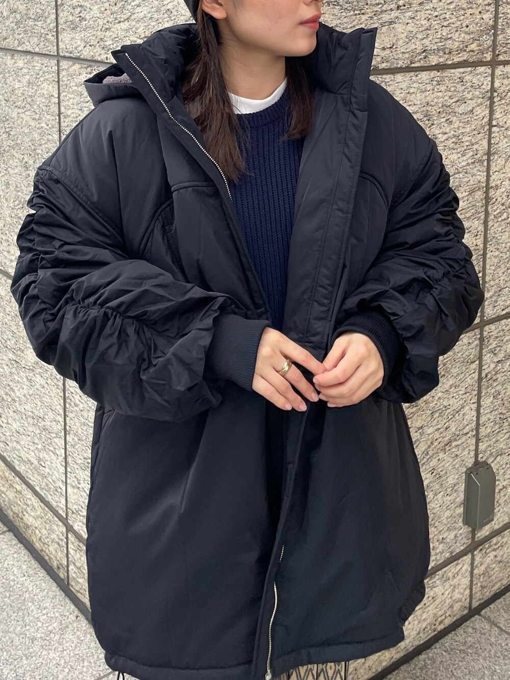 ブルー系のニット/セーター、ブラック系のブルゾンを着用したレディースの秋コーディネートの6枚目の写真