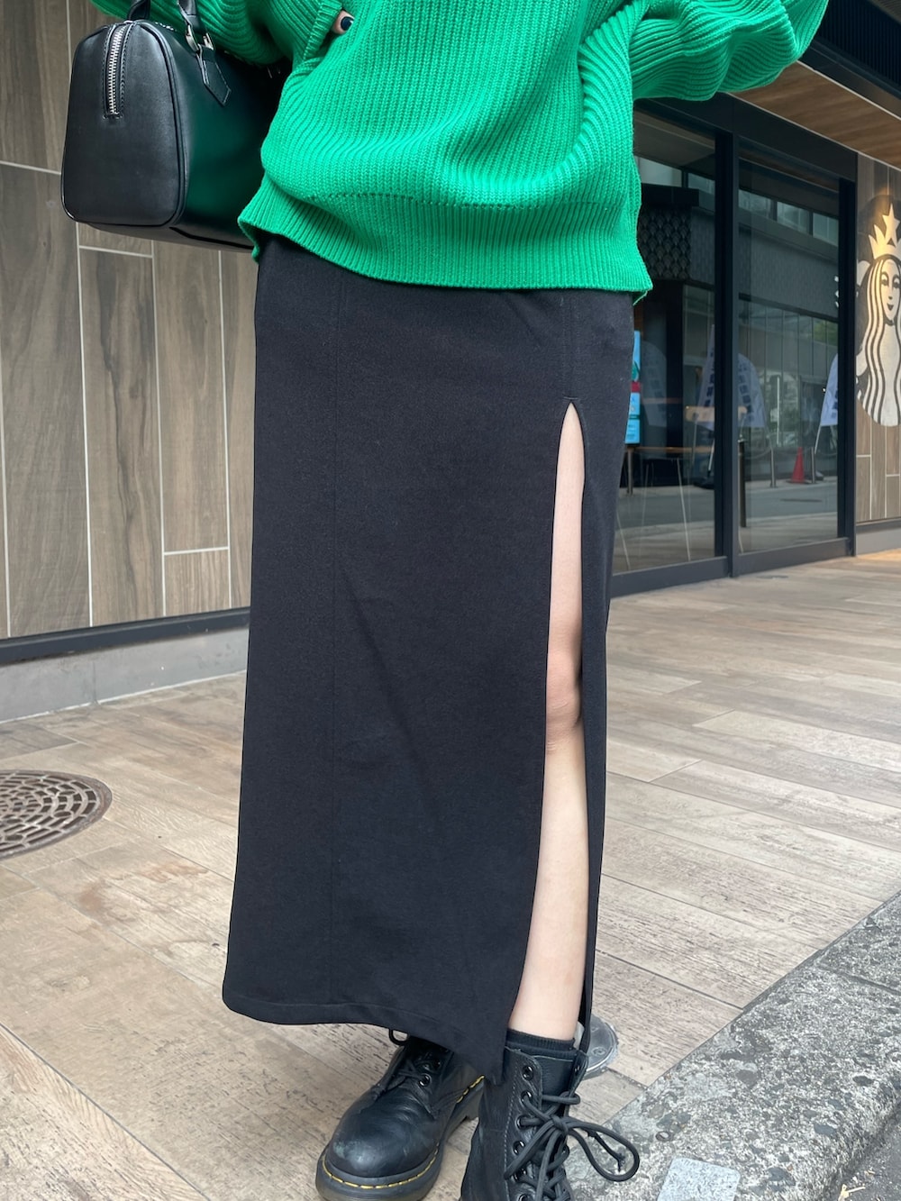 グリーン系のニット/セーター、ブラック系のスカートを着用したレディースの冬コーディネートの8枚目の写真