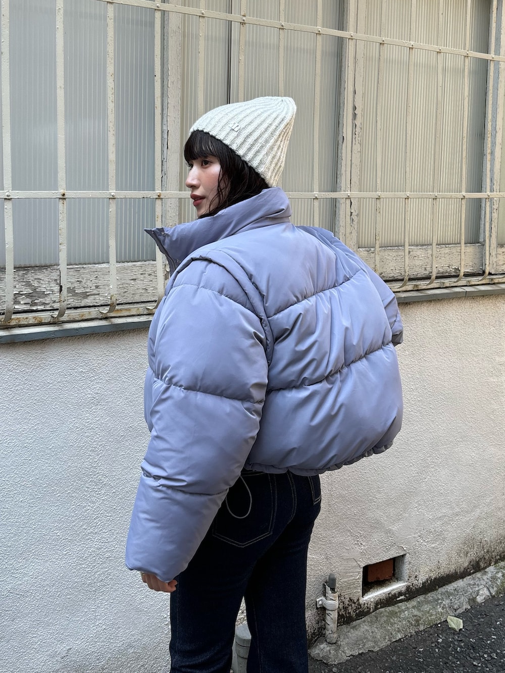 パープル系のニット/セーター、ブルー系のブルゾン、ブルー系のデニムパンツを着用したレディースの秋コーディネートの4枚目の写真