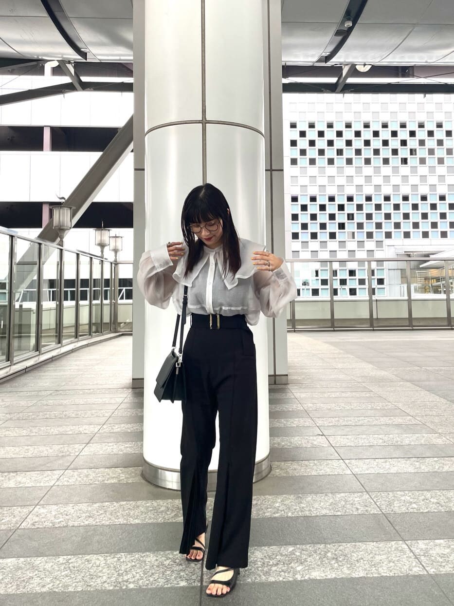 ブラック系のその他パンツ、ブラック系のサンダル、ホワイト系のシャツ/ブラウスを着用したレディースの夏コーディネートの2枚目の写真