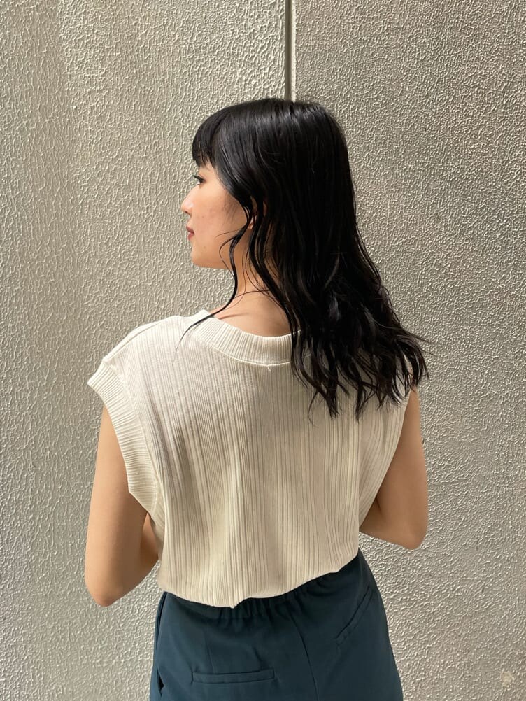 グリーン系のスラックス、ブラック系のサンダル、ホワイト系のTシャツ/カットソーを着用したレディースの夏コーディネートの3枚目の写真