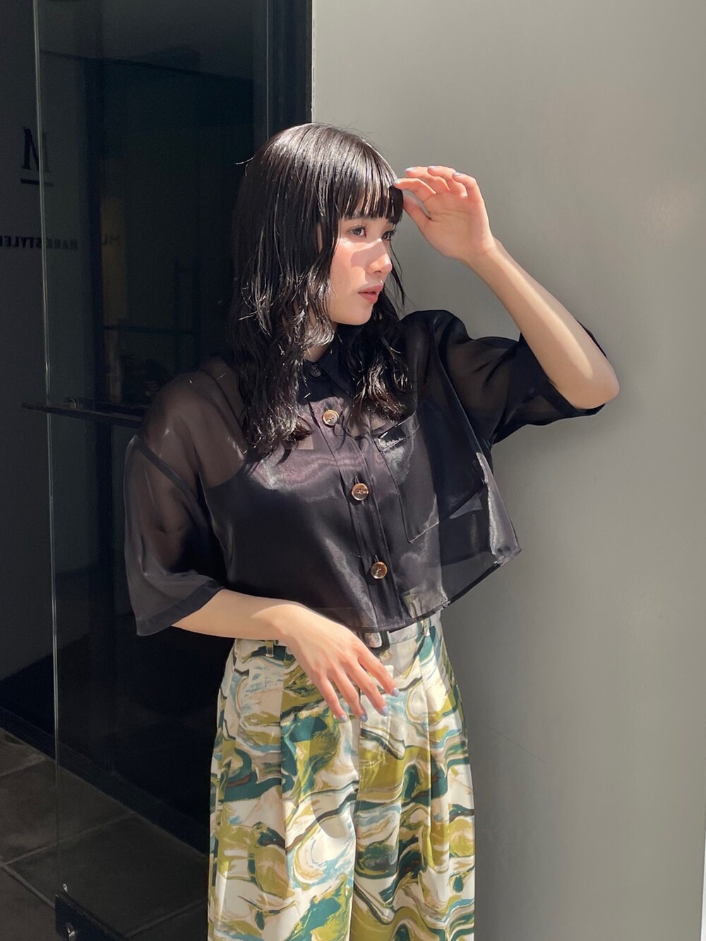 ブラック系のシャツ/ブラウス、グリーン系のスラックス、ブラック系のサンダルを着用したレディースの春コーディネートの3枚目の写真