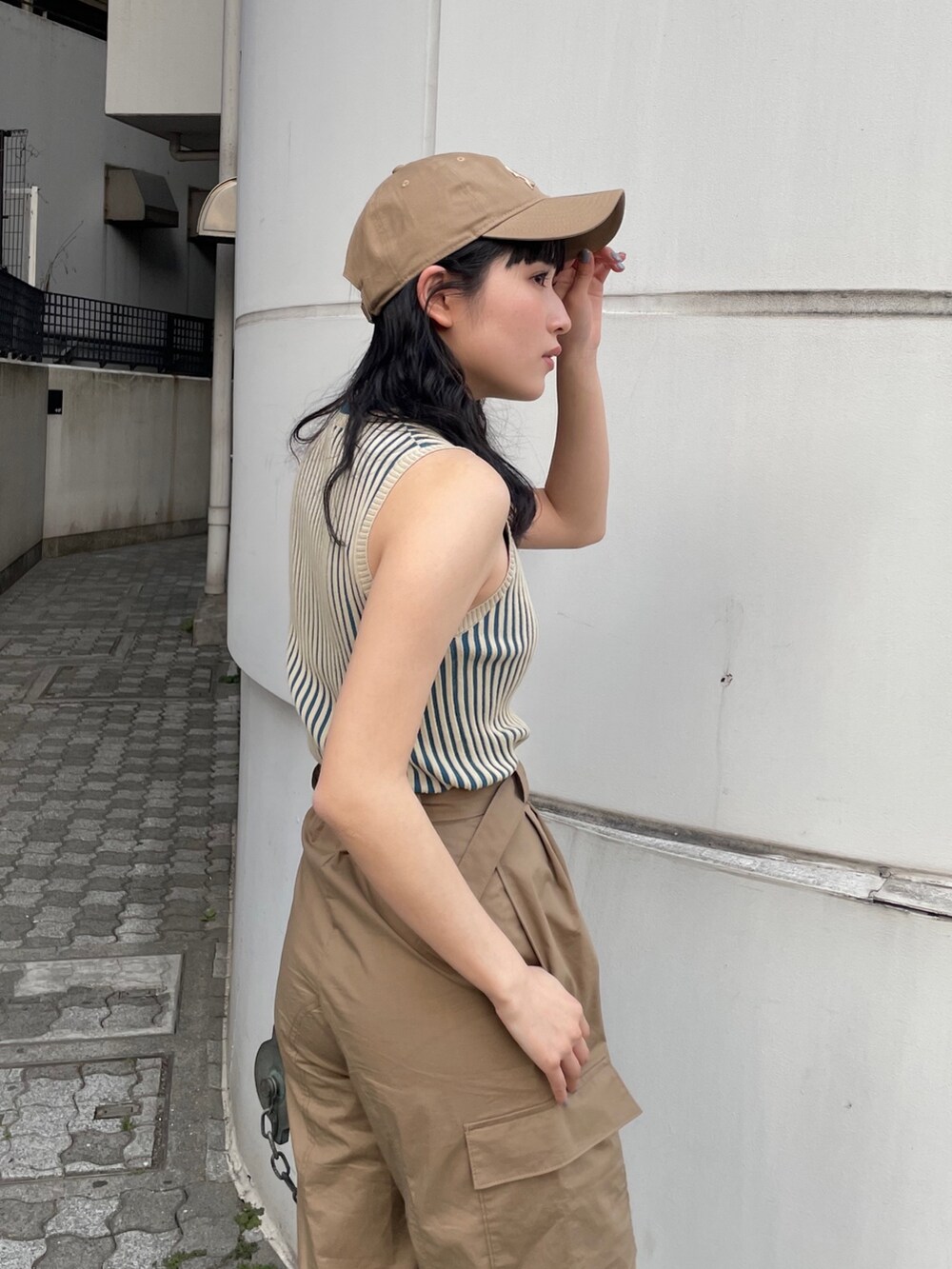 グリーン系のカーゴパンツ、ベージュ系のニット/セーター、ベージュ系のキャップを着用したレディースの春コーディネートの5枚目の写真