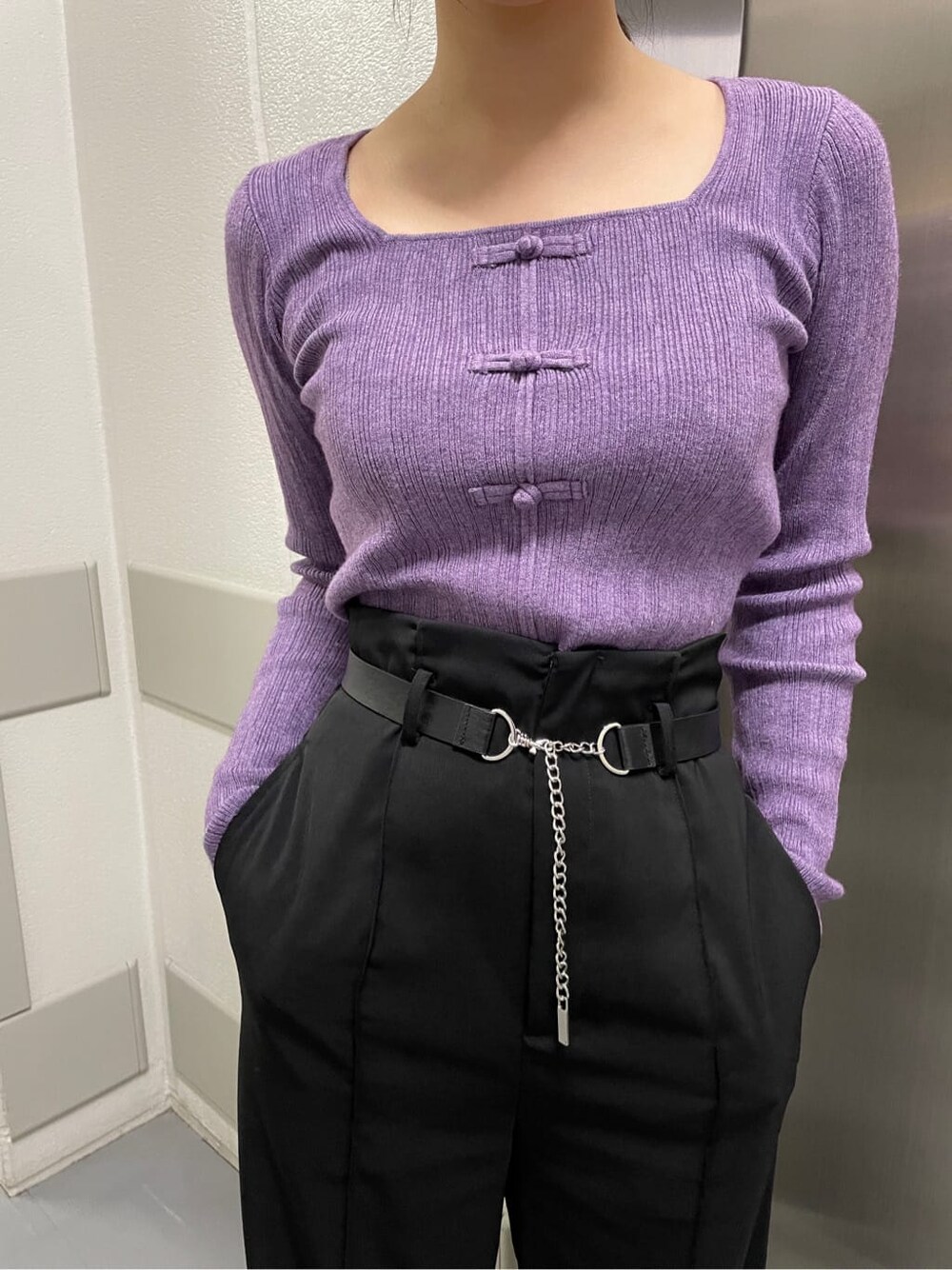 パープル系のニット/セーター、ブラック系のスラックスを着用したレディースの秋コーディネートの2枚目の写真