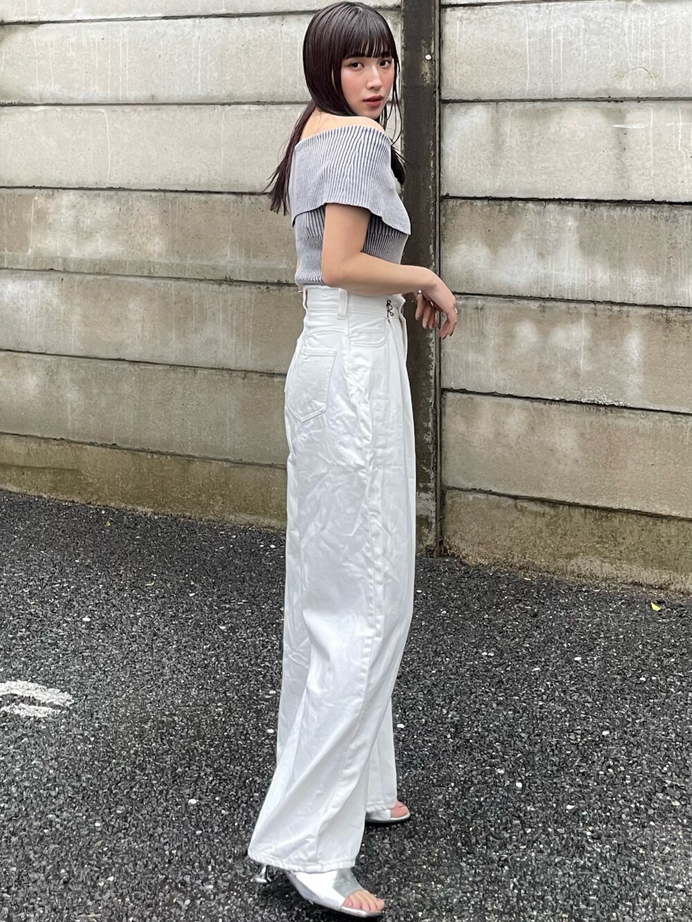 ホワイト系のニット/セーター、ホワイト系のデニムパンツを着用したレディースの春コーディネートの3枚目の写真