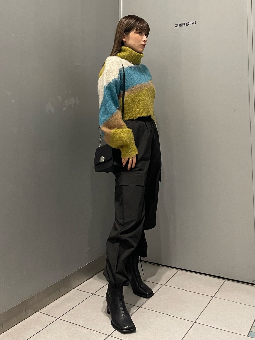 その他のニット/セーター、ブラック系のブーツ、ブラック系のショルダーバッグを着用したレディースの秋コーディネートの2枚目の写真