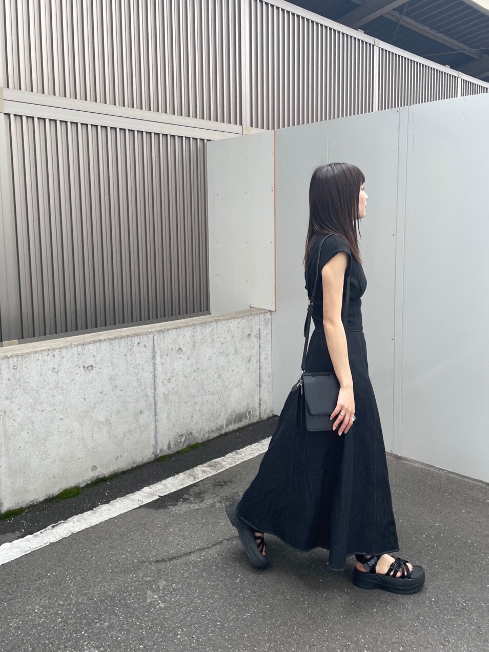 ブラック系のワンピース、ブラック系のサンダル、ブラック系のハンドバッグを着用したレディースの春コーディネートの6枚目の写真