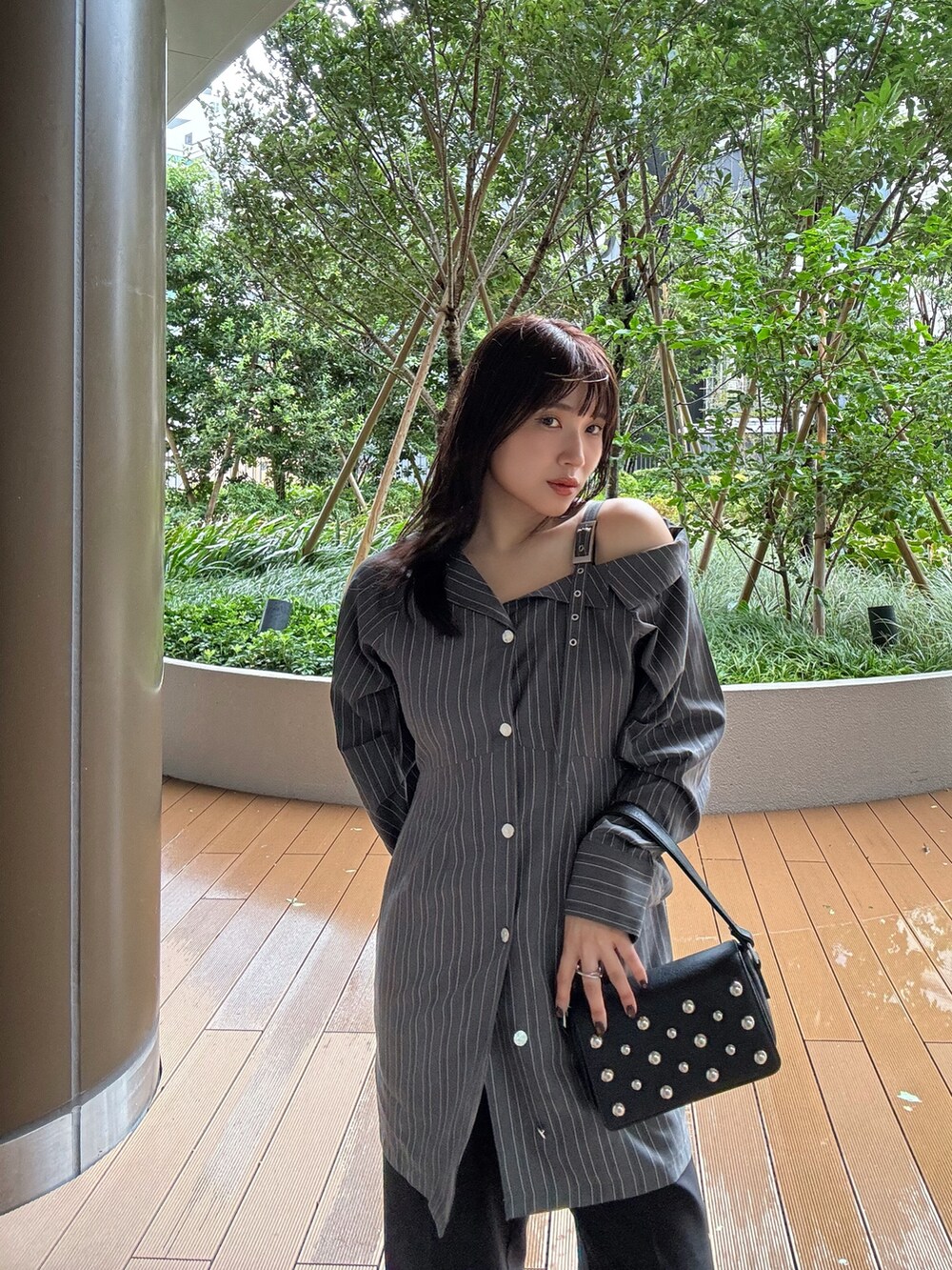 グレー系のワンピース、ブラック系のスラックス、ブラック系のサンダルを着用したレディースの夏コーディネートの2枚目の写真