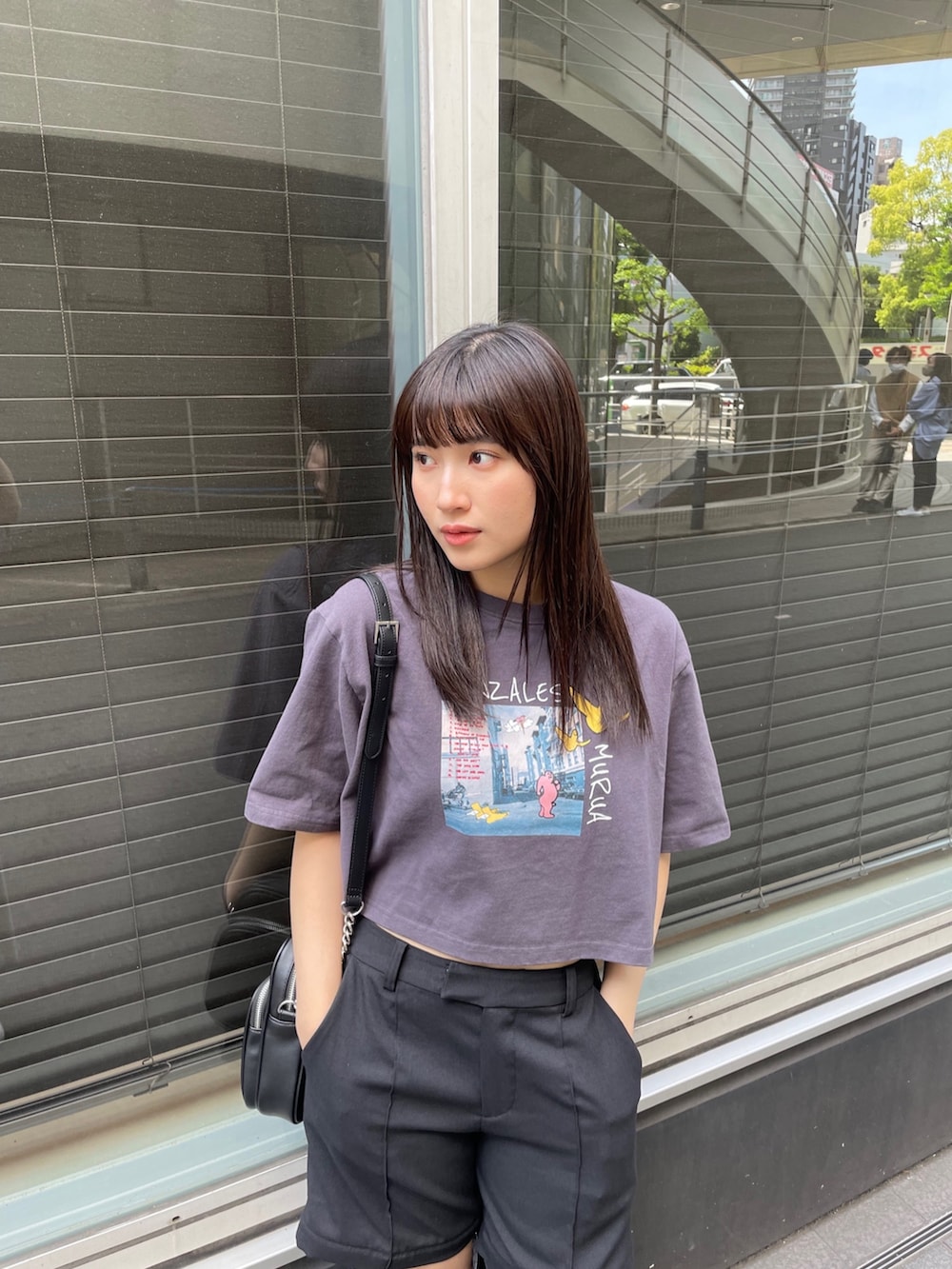 ブラック系のスラックス、ホワイト系のTシャツ/カットソーを着用したレディースの春コーディネートの2枚目の写真