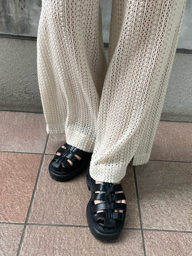 ホワイト系のスウェットパンツ、グリーン系のタンクトップ、ブラック系のサンダルを着用したレディースの春コーディネートの8枚目の写真