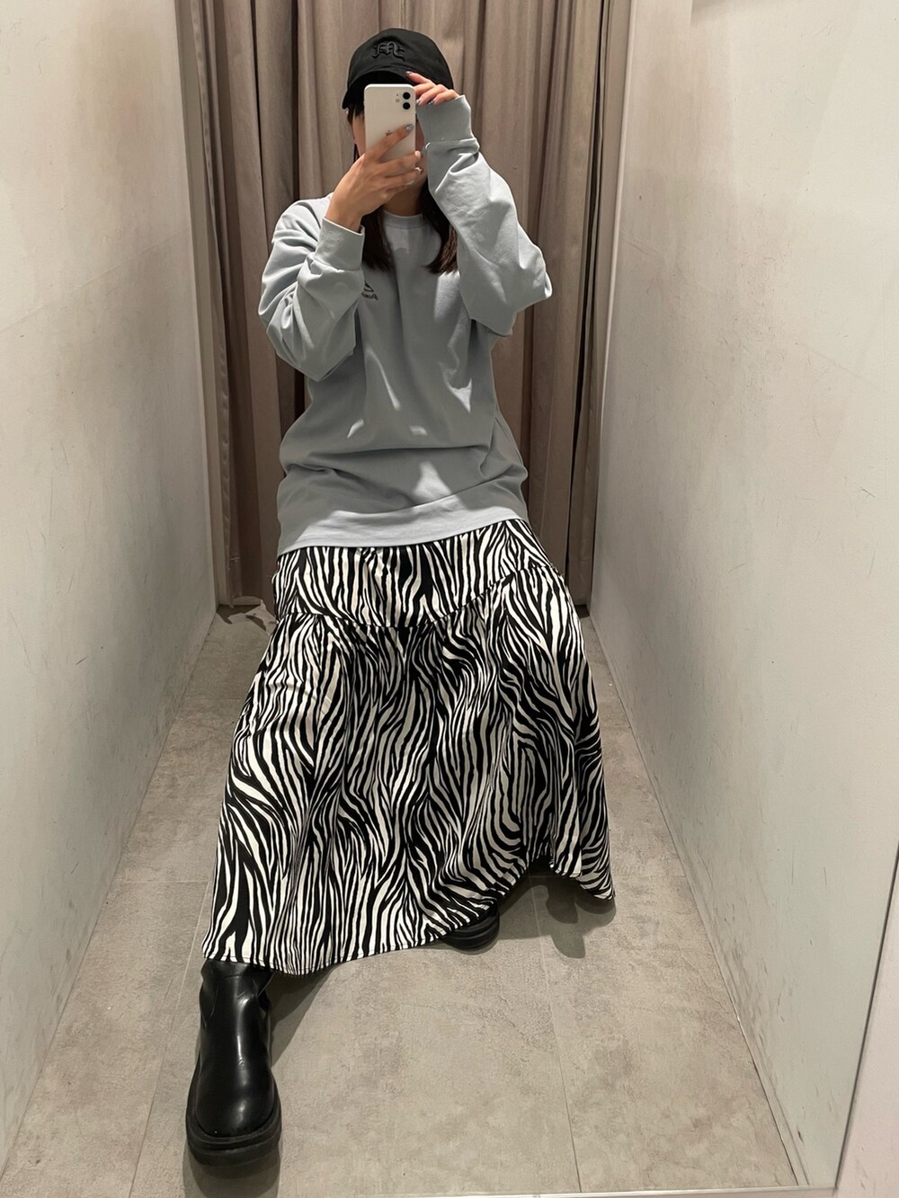 ホワイト系のスカート、ブルー系のTシャツ/カットソー、ブラック系のキャップを着用したレディースの冬コーディネートの4枚目の写真