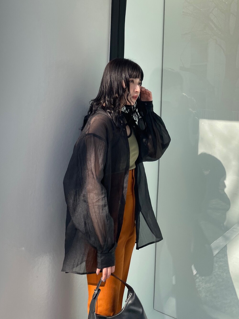 ブラック系のシャツ/ブラウス、グリーン系のタンクトップ、ブラック系のサンダルを着用したレディースの春コーディネートの5枚目の写真